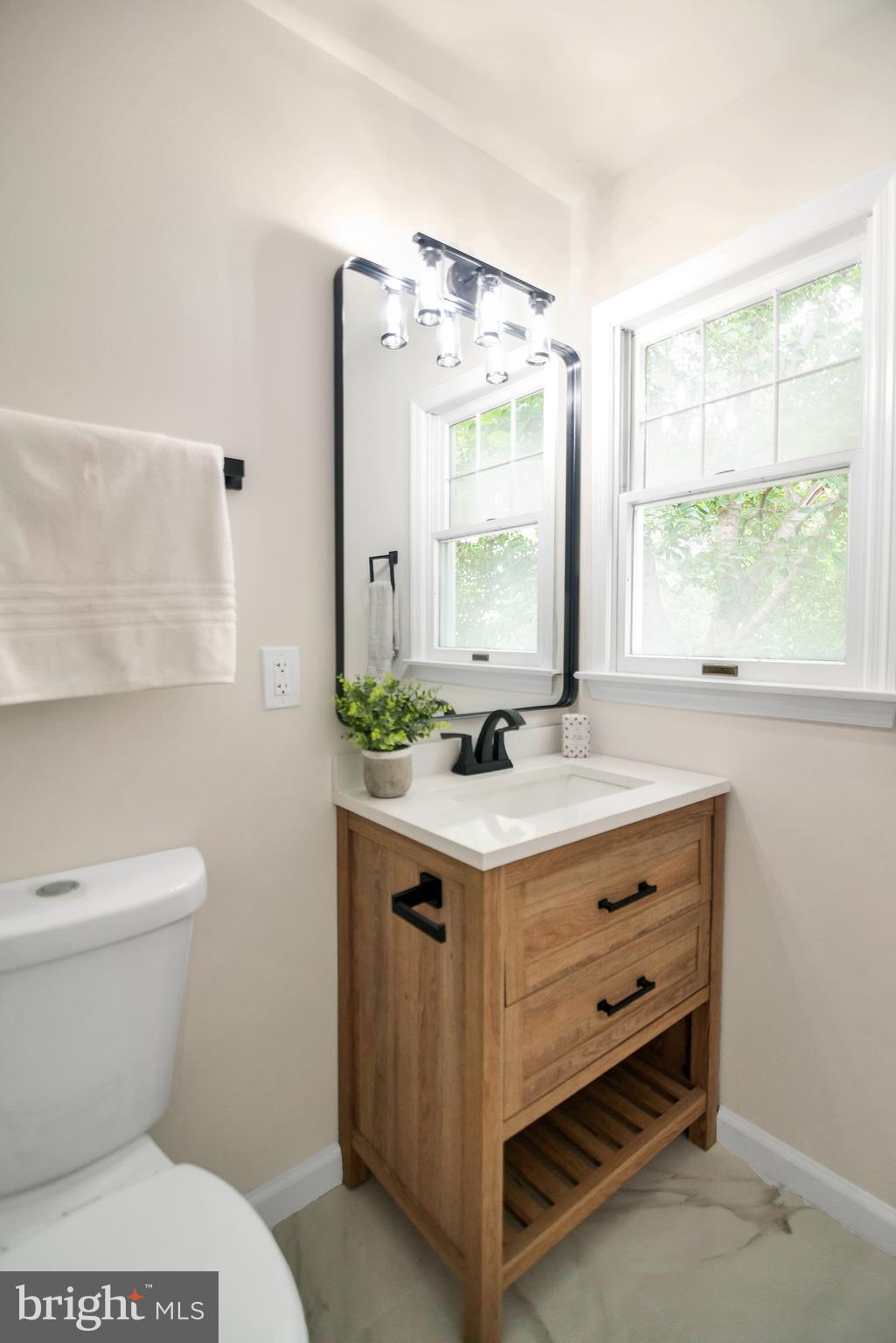 5809 Shana Place Burke, VA 22015 - Photo 29 of 46 a bathroom with a sink toilet and window