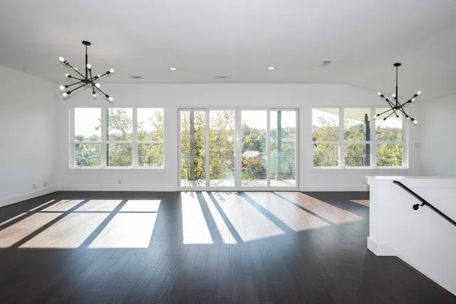 a bedroom with a bed chandelier and a view of kitchen