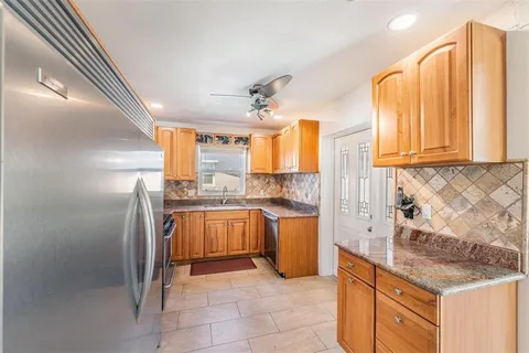 a kitchen with stainless steel appliances granite countertop a stove a sink and a refrigerator