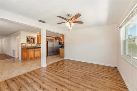 a view of a kitchen with wooden floor and a ceiling fan