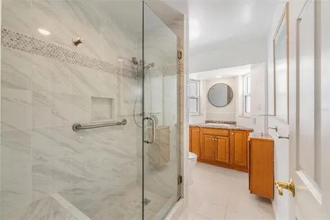 a bathroom with a granite countertop sink a mirror and shower