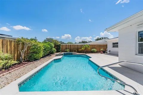 a swimming pool with outdoor seating and yard