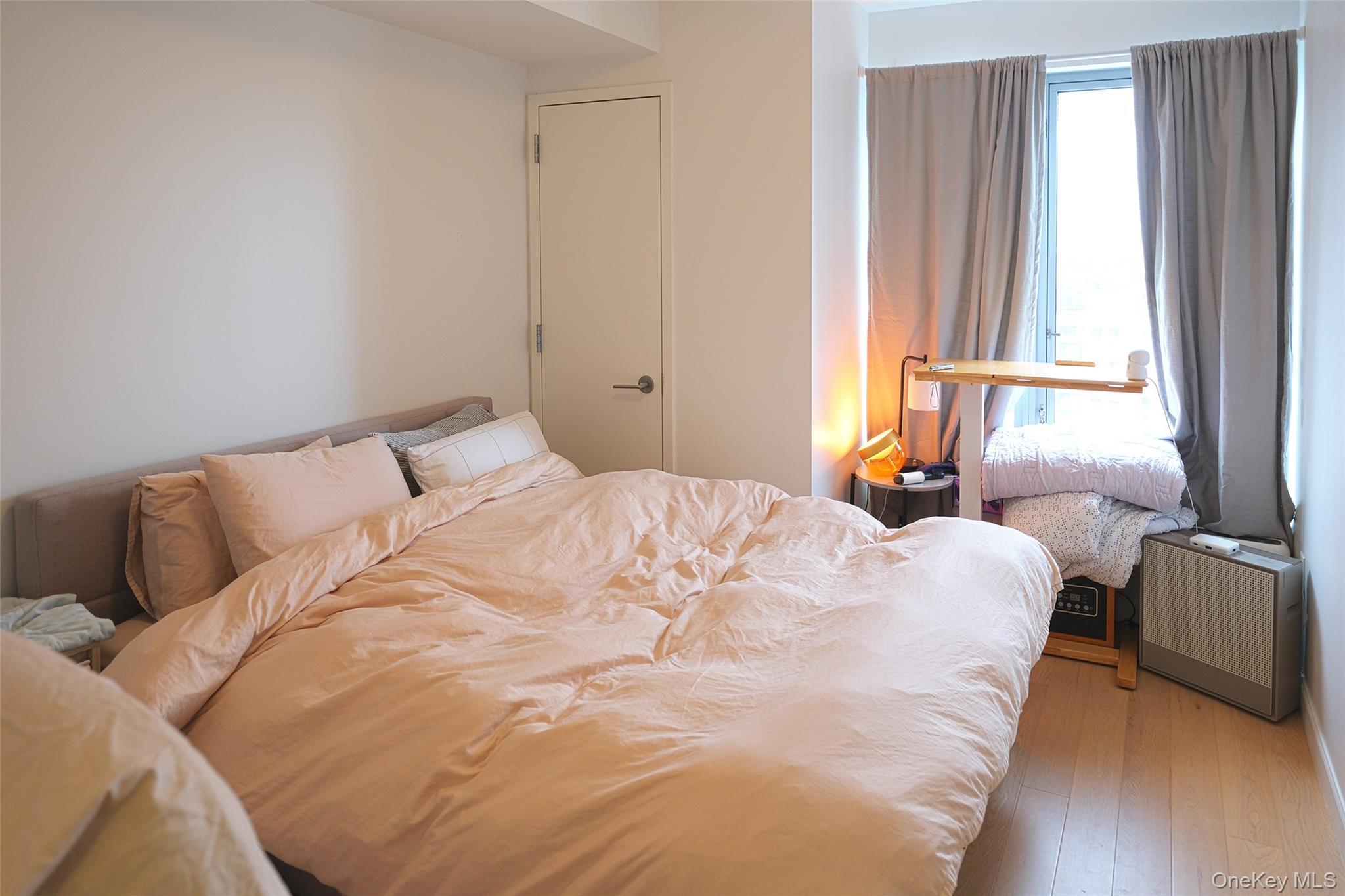 138-35 39th Avenue, Unit 12L Queens, NY 11354 - Photo 5 of 17 a bedroom with a bed and a window