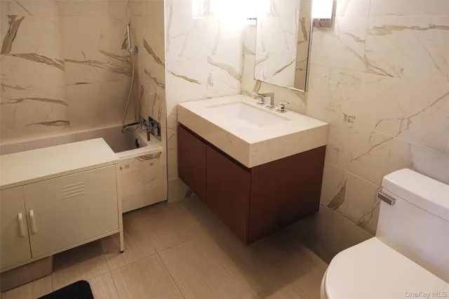a bathroom with a sink mirror vanity and toilet