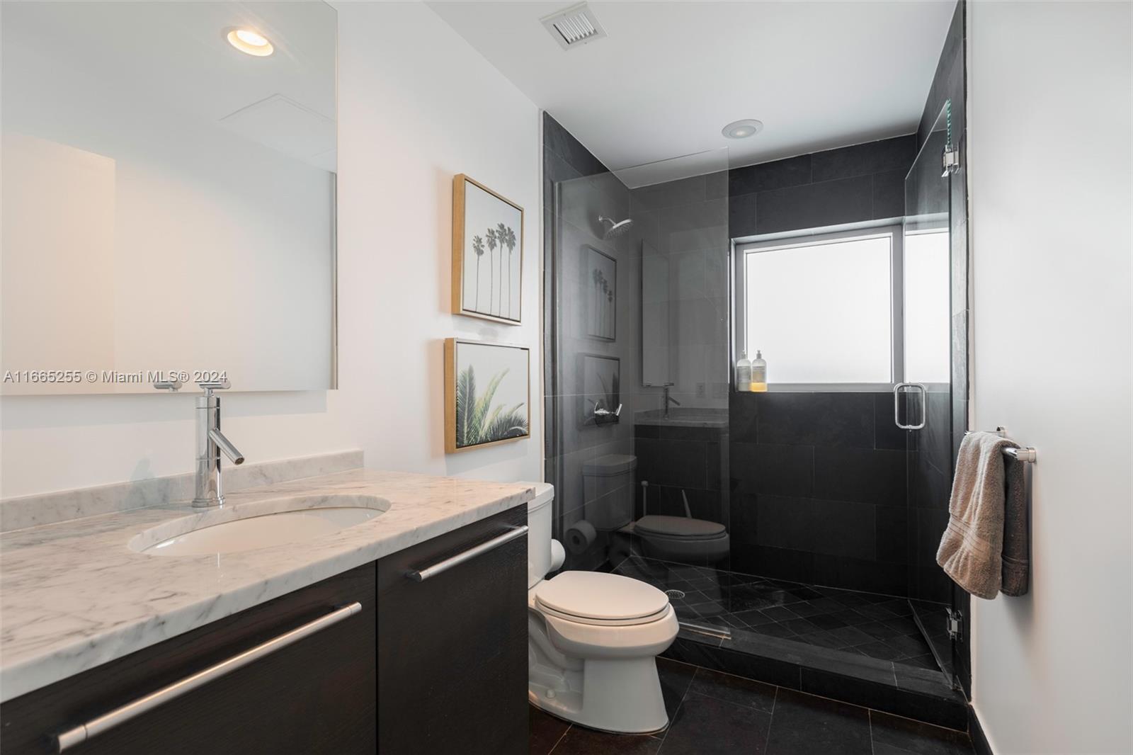 900 Biscayne Boulevard, Unit 3609 Miami, FL 33132 - Photo 17 of 36 a bathroom with a granite countertop toilet sink and shower