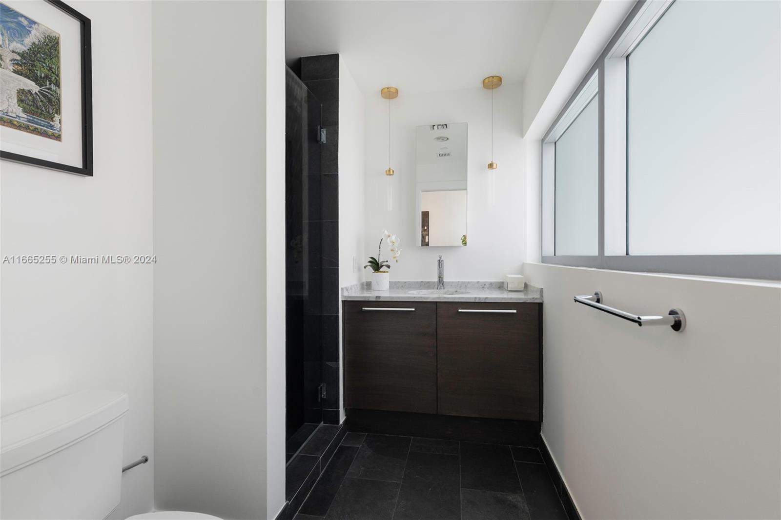 900 Biscayne Boulevard, Unit 3609 Miami, FL 33132 - Photo 18 of 36 a bathroom with a sink and mirror with toilet