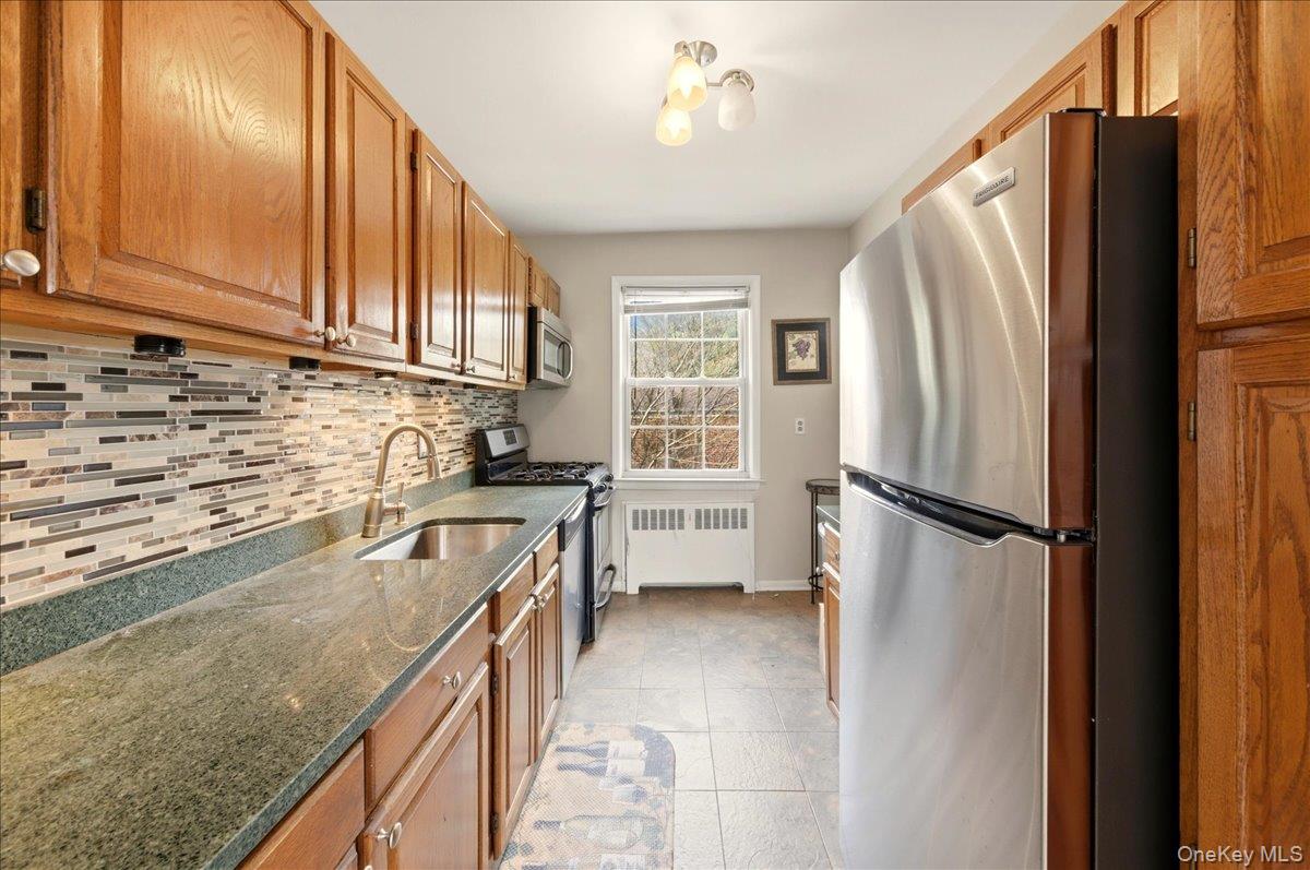 186 Pinewood Road, Unit 56 Hartsdale, NY 10530 - Photo 14 of 20 a kitchen with stainless steel appliances granite countertop a refrigerator a sink and a stove