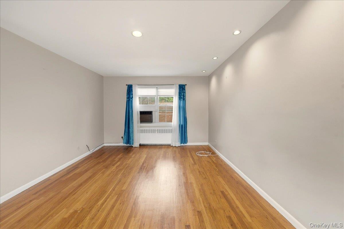 186 Pinewood Road, Unit 56 Hartsdale, NY 10530 - Photo 7 of 20 a view of an empty room with wooden floor and a window