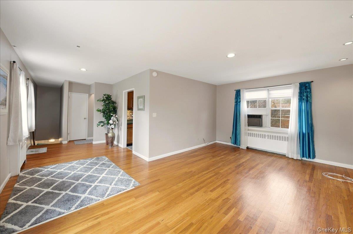 186 Pinewood Road, Unit 56 Hartsdale, NY 10530 - Photo 10 of 20 a view of an empty room with wooden floor and a window