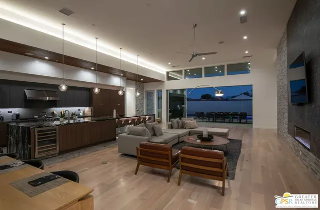 a living room with furniture a flat screen tv and kitchen view