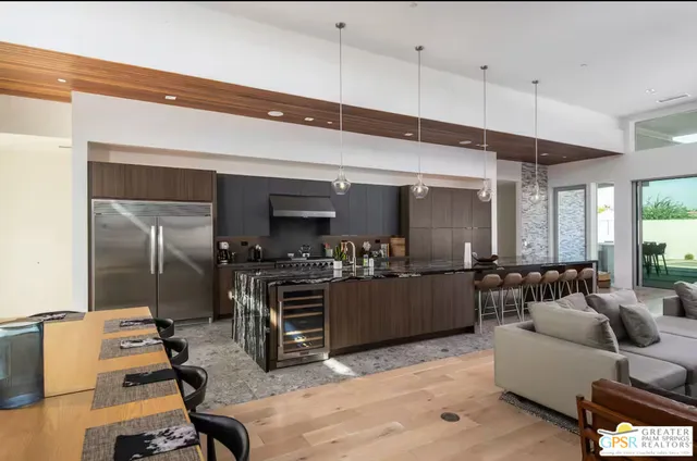 a living room with furniture a flat screen tv and kitchen view