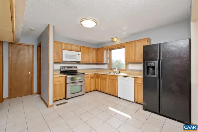 a kitchen with a refrigerator sink and cabinets