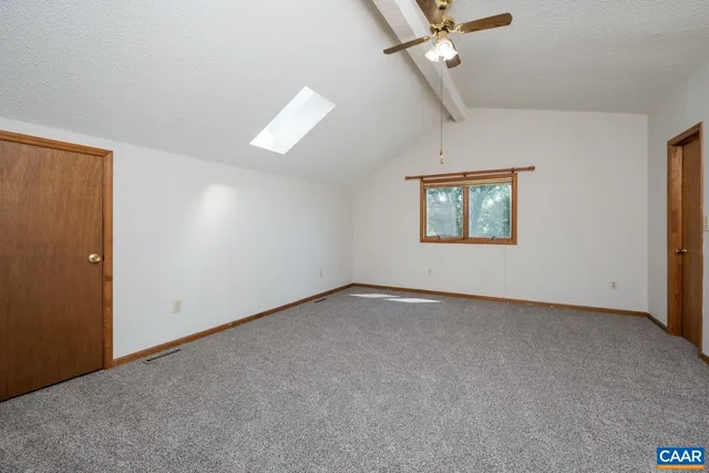 an empty room with windows and ceiling fan