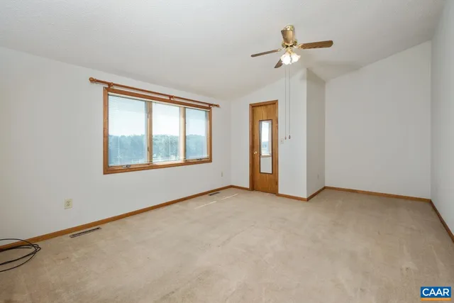 an empty room with fan and windows