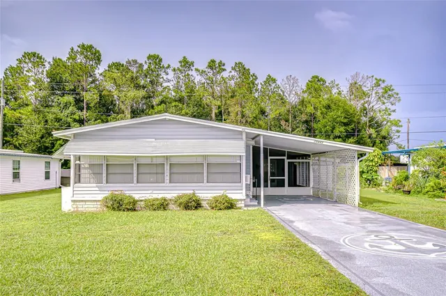 a front view of a house with a yard and potted plants