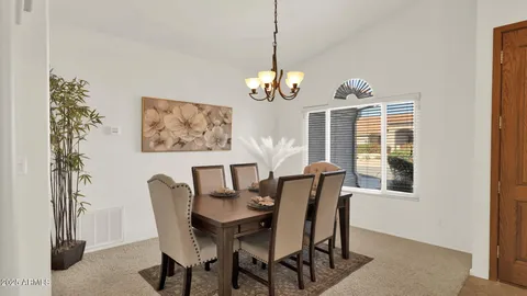 a view of a dining room and livingroom with furniture wooden floor a chandelier