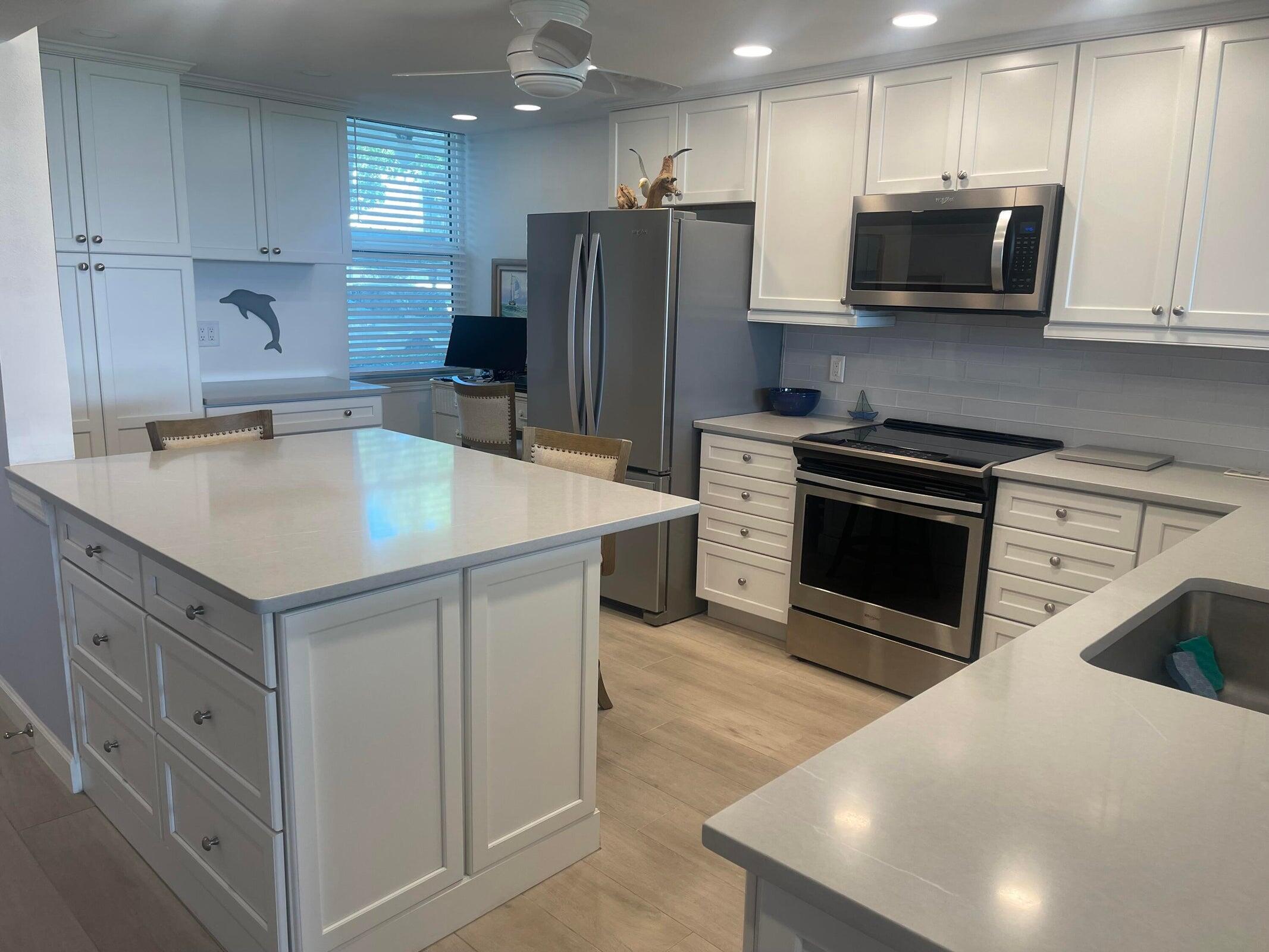 1950 Southwest Palm City Road, Unit 13104 Stuart, FL 34994 - Photo 3 of 12 a kitchen with stainless steel appliances granite countertop a sink stove and refrigerator