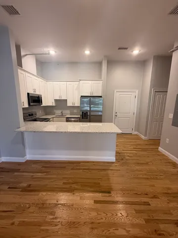 a view of kitchen with stainless steel appliances granite countertop a stove and a sink