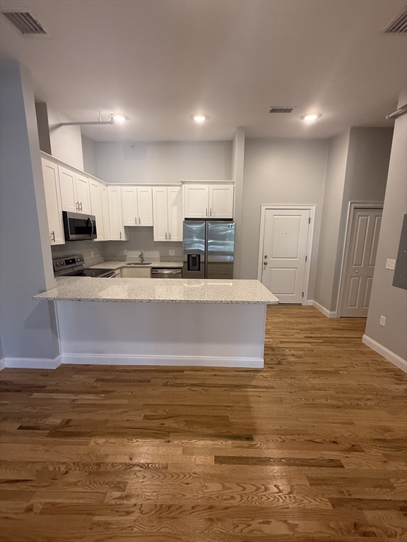 a view of kitchen with stainless steel appliances granite countertop a stove and a sink