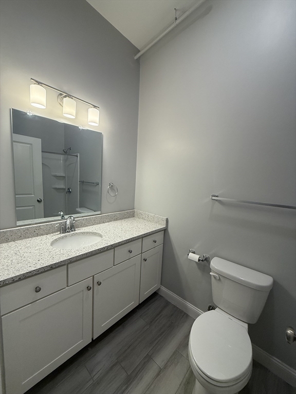 20 Locust Street, Unit 311 Danvers, MA 01923 - Photo 13 of 13 a bathroom with a granite countertop toilet sink and mirror