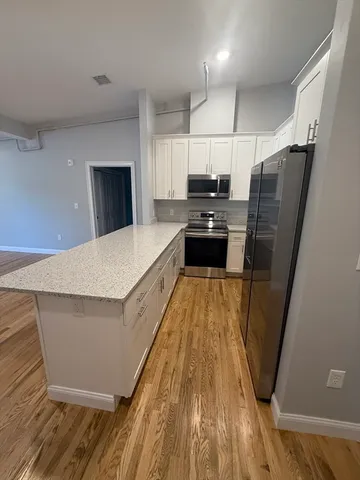 a large kitchen with a sink a refrigerator and a stove top oven