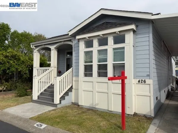 a view of a house with a small yard and wooden fence