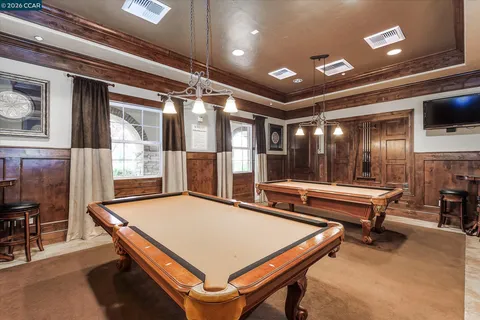a room with pool table and windows