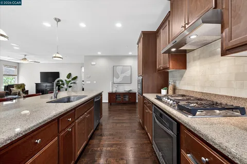a kitchen with stainless steel appliances kitchen island a large stove a sink dishwasher with wooden floor
