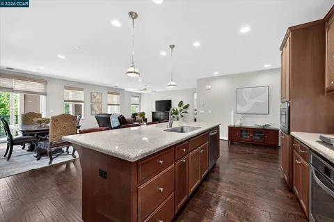 a view of kitchen island a sink wooden floor dining table and chairs