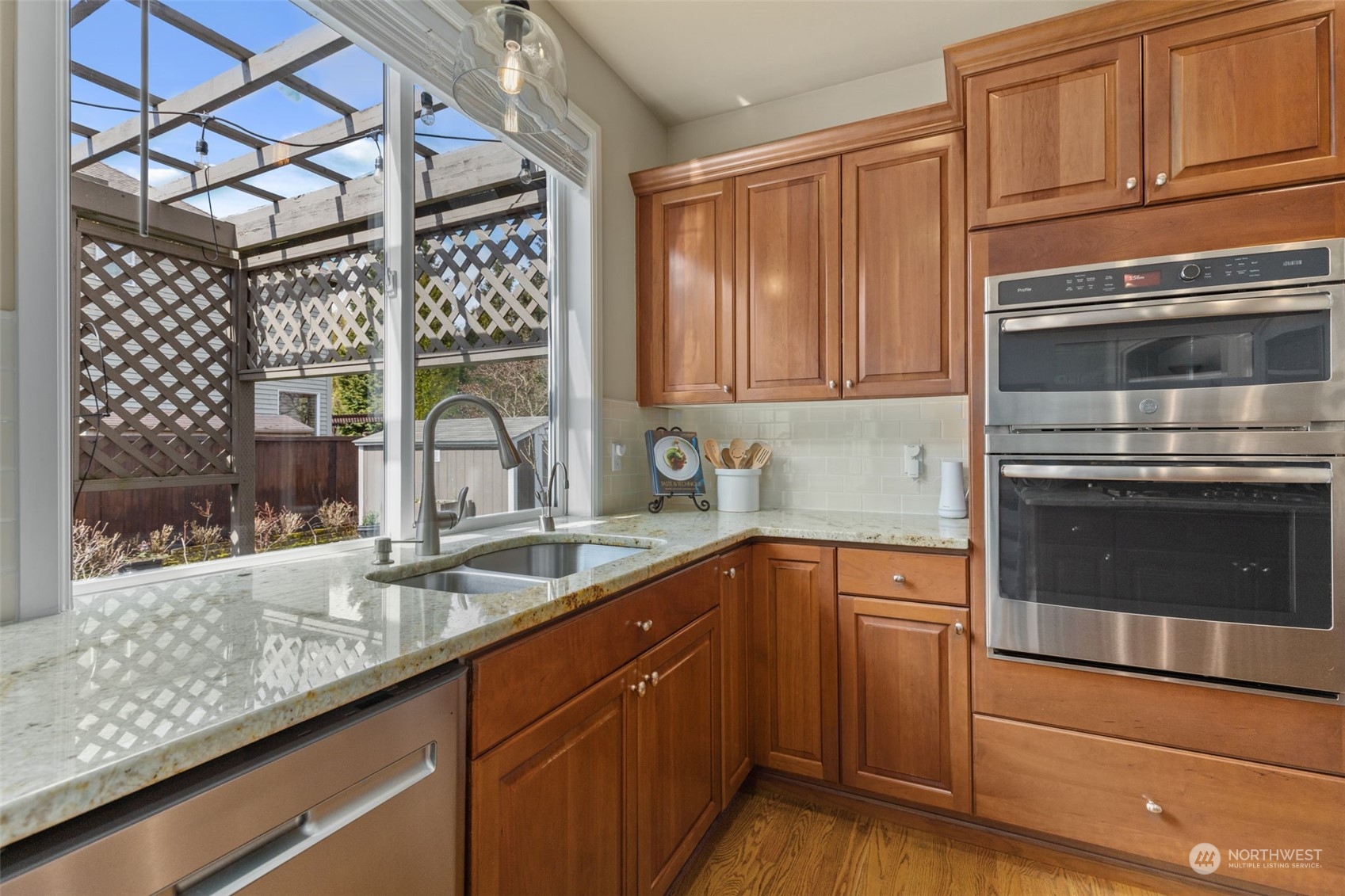20828 37th Avenue Southeast Bothell, WA 98021 - Photo 6 of 38 a kitchen with granite countertop a sink stainless steel appliances wooden floor and a counter top space