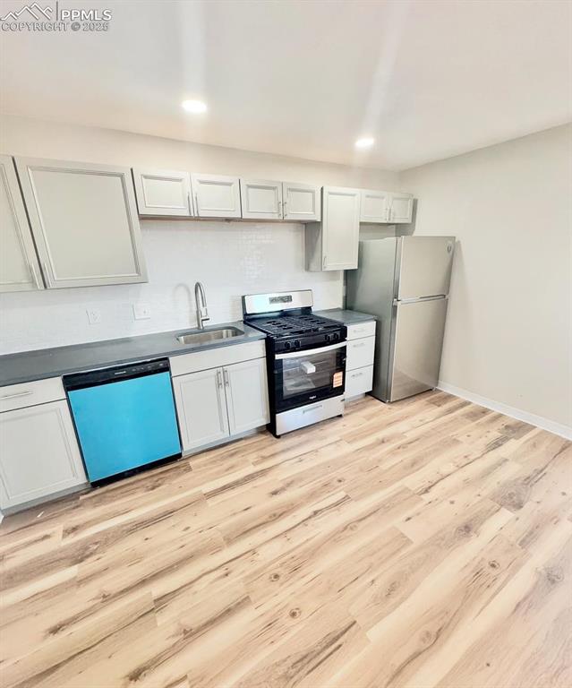 716-718 West Madison Street Colorado Springs, CO 80907 - Photo 3 of 8 a kitchen with stainless steel appliances kitchen island a refrigerator sink and stove