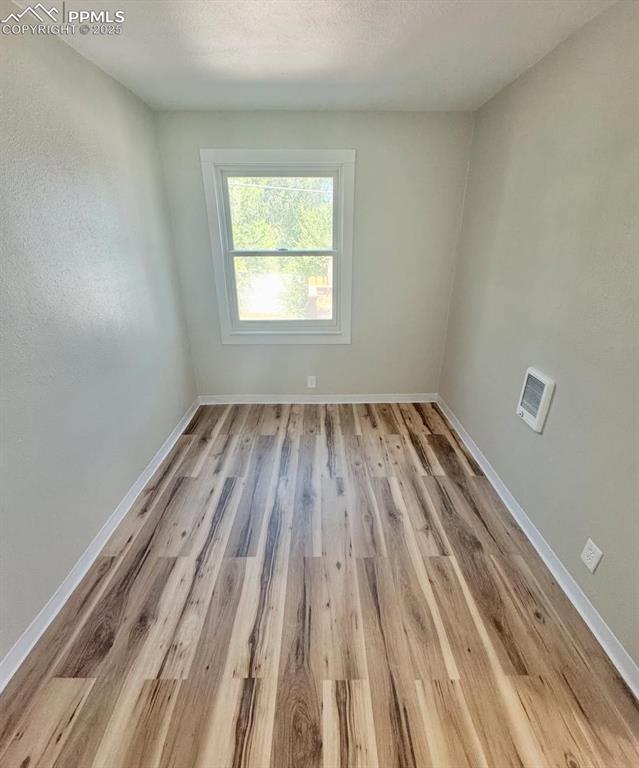 716-718 West Madison Street Colorado Springs, CO 80907 - Photo 8 of 8 a view of an empty room with wooden floor and a window