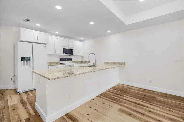 a kitchen with stainless steel appliances granite countertop a stove a sink and a refrigerator