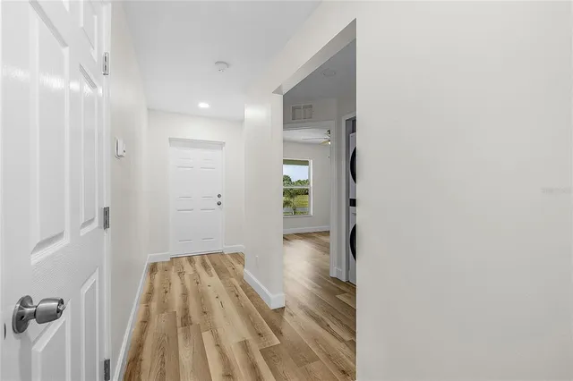 a view of a room with wooden floor and a ceiling fan