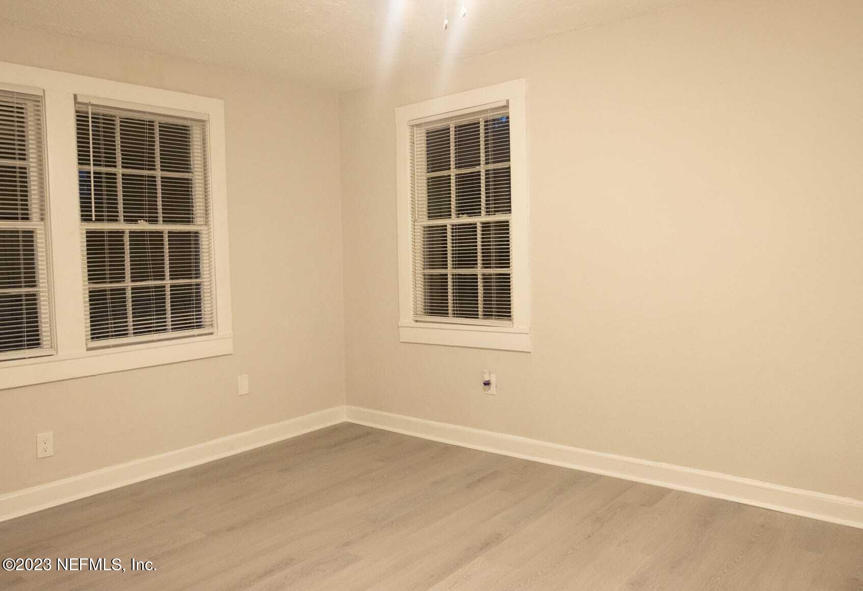 3910 Grant Road Jacksonville, FL 32207 - Photo 15 of 32 an empty room with wooden floor and windows
