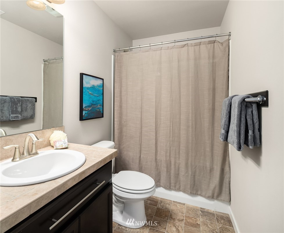 5 157th Lane Southeast Bothell, WA 98012 - Photo 19 of 27 a bathroom with a sink a toilet a mirror and shower curtain