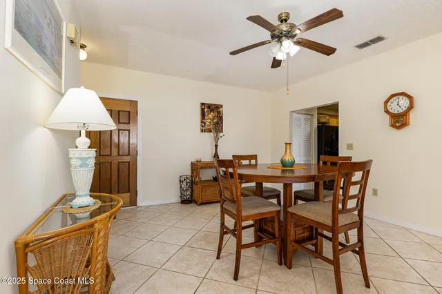 a view of a dining room with furniture and a chandelier fan