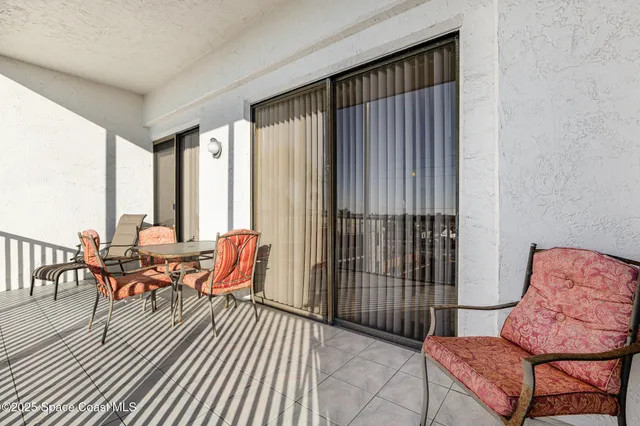 a living room filled with furniture and large windows