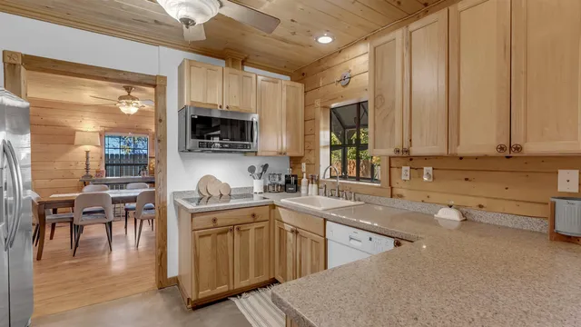 a kitchen with stainless steel appliances granite countertop a stove a sink dishwasher and a microwave oven with wooden floor