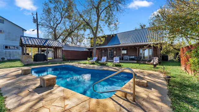 a view of a house with swimming pool and sitting area