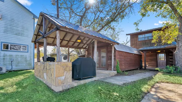 a view of a house with a yard and wooden fence