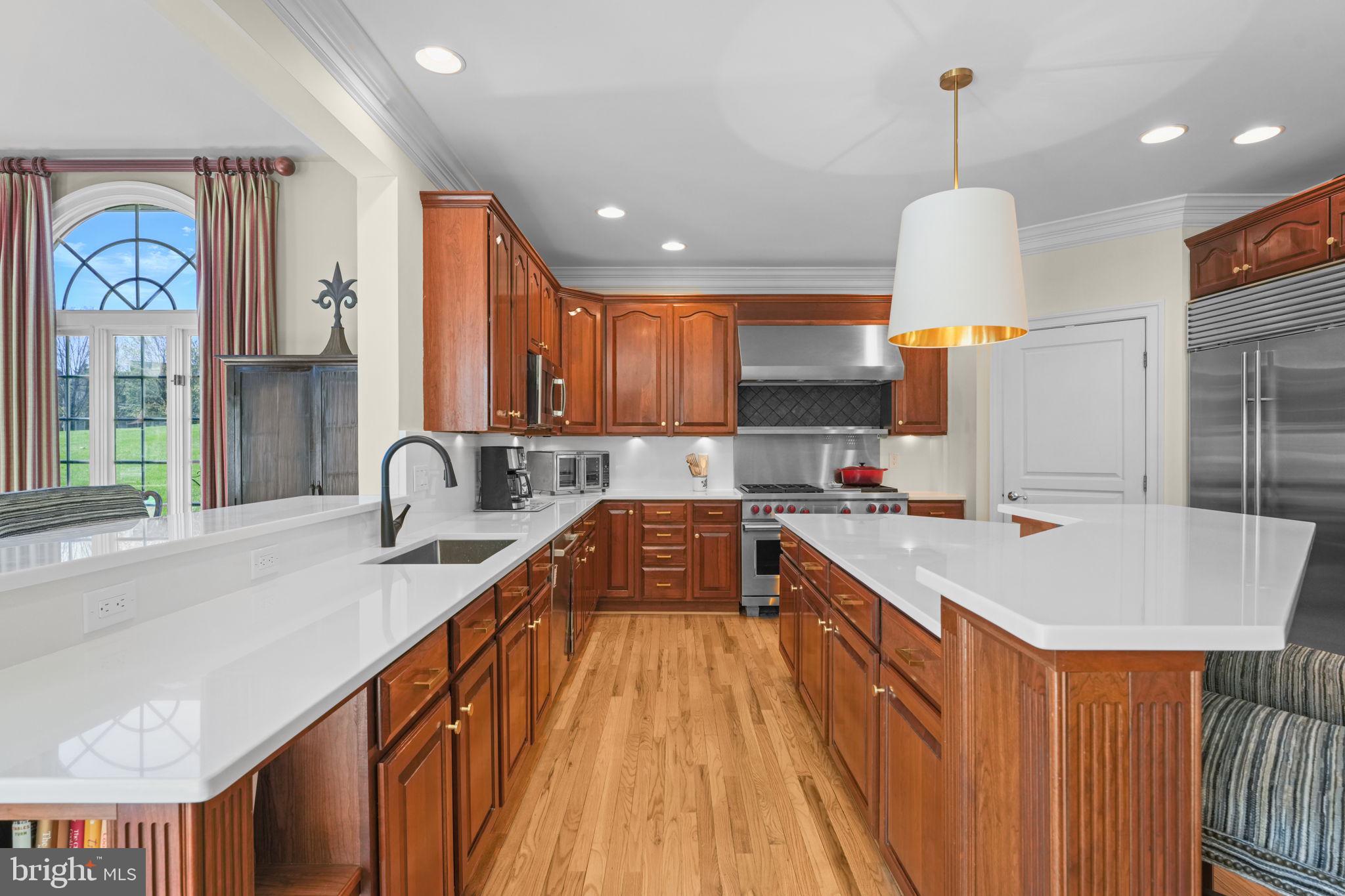 11431 Woolington Road Great Falls, VA 22066 - Photo 3 of 49 a large kitchen with stainless steel appliances granite countertop a sink a stove and a wooden floors