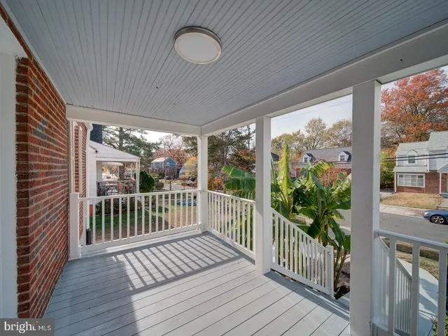 a view of a porch with wooden floor in front of a house