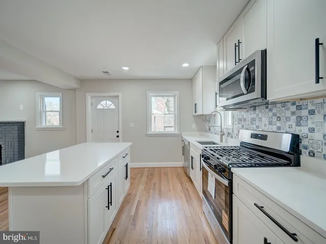 a kitchen with granite countertop a sink stove and cabinets
