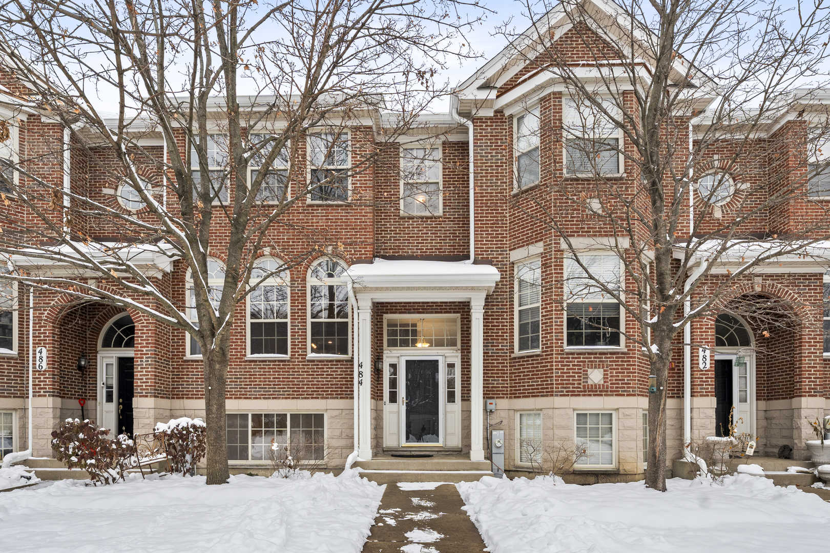 a front view of a brick house with large windows