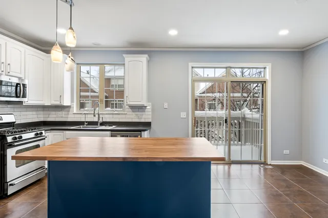 a kitchen with stainless steel appliances granite countertop a sink window and cabinets