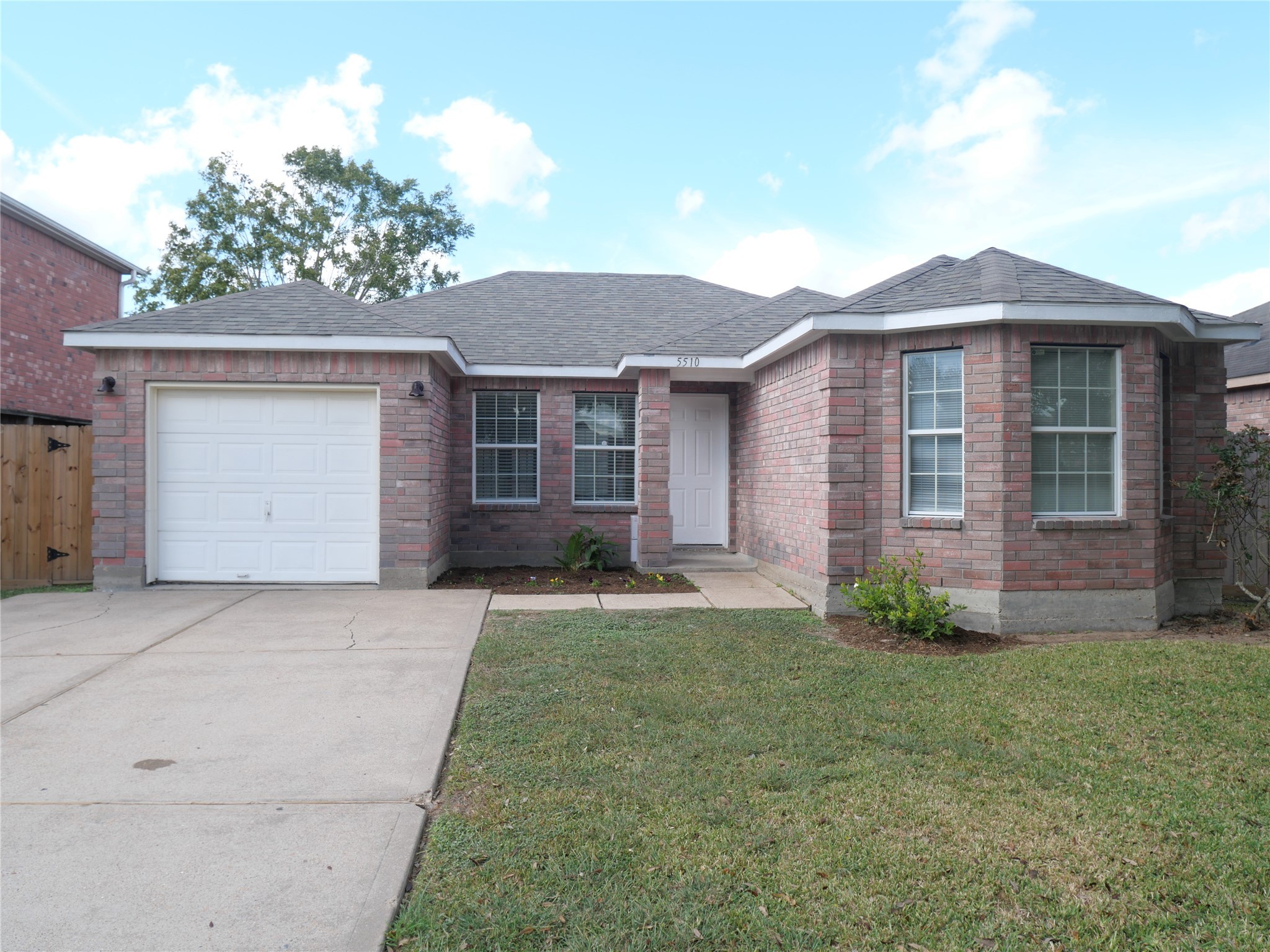 a front view of a house with a garden and yard