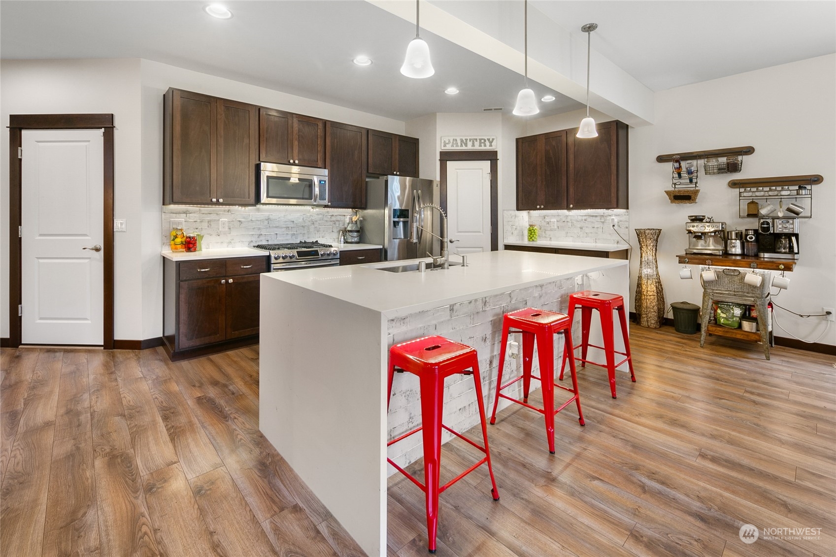 17601 3rd Avenue Southeast Bothell, WA 98012 - Photo 12 of 31 a kitchen with stainless steel appliances granite countertop a refrigerator a stove top oven a sink dishwasher and white cabinets with wooden floor
