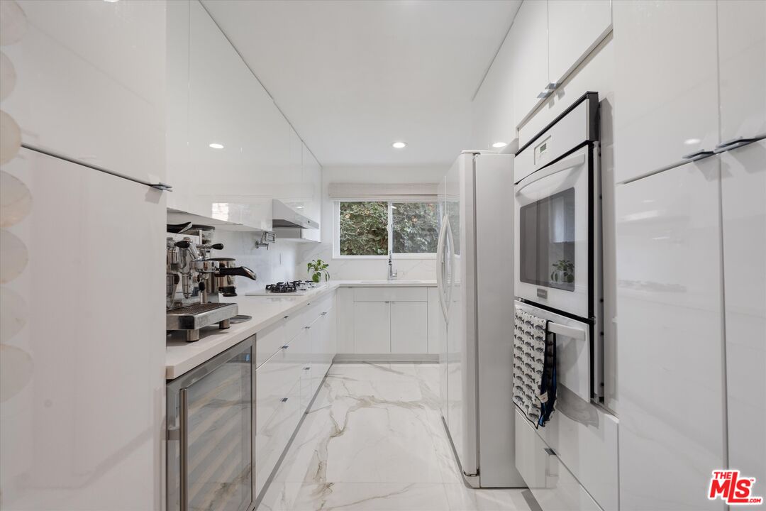 1327 Stanford Street, Unit 3 Santa Monica, CA 90404 - Photo 2 of 12 a kitchen with white cabinets and refrigerator