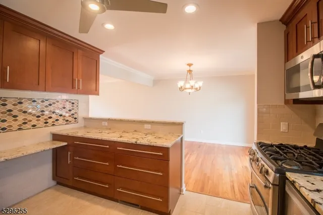 a kitchen with granite countertop a stove and cabinets